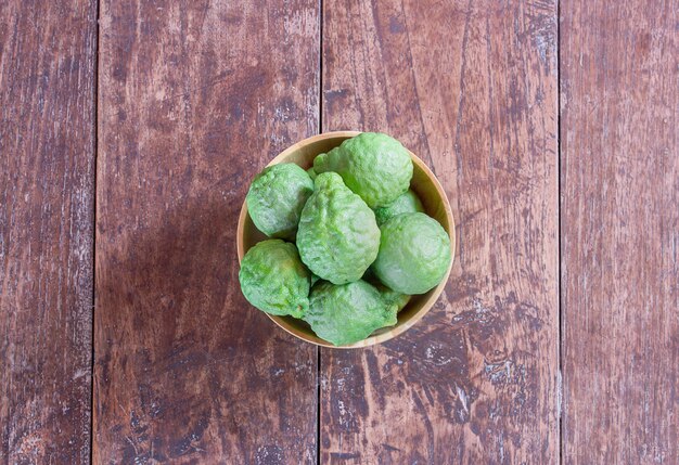 Fresh bergamot and bergamot slice in wooden bowl