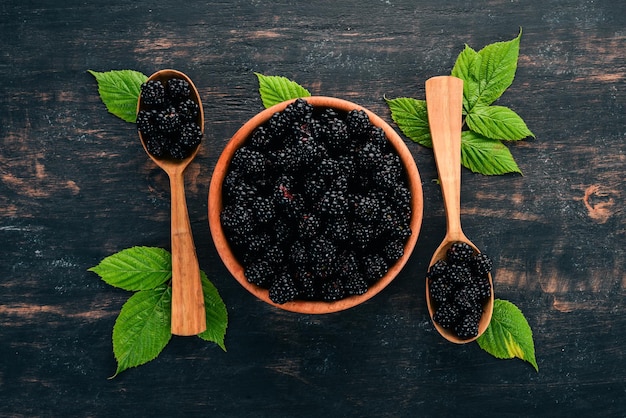 Fresh berries blackberries On a black wooden background Top view Free space for text