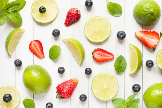 Fresh berries of citrus lime mint blueberries strawberry on a light background with Flat lay of summer