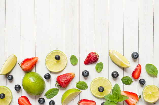 Photo fresh berries of citrus lime mint blueberries strawberry on a light background