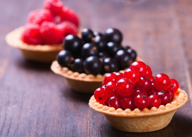 fresh berries tartlets on wooden backraunds