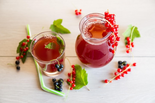 Fresh berry juice from red and black currant on a wooden table