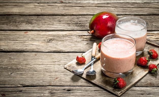 Fresh berry smoothie. On a wooden background.