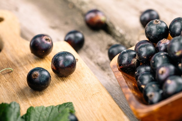 Fresh black currant. A handful of berries on a wooden table.