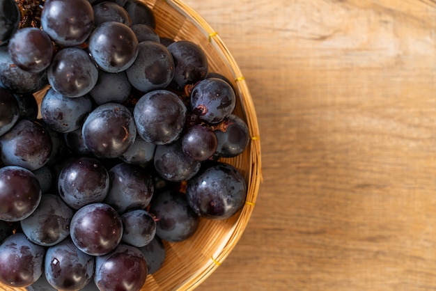 fresh black grapes on white table