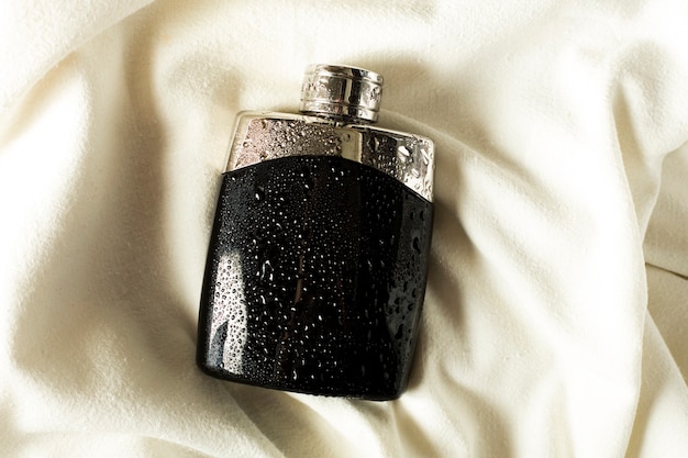 Fresh black perfume on white fabric