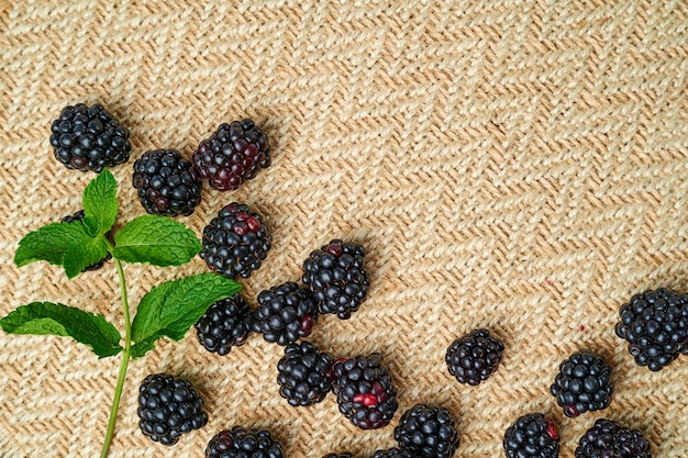 Photo fresh blackberries scattered on beige kraft fabric with space for text