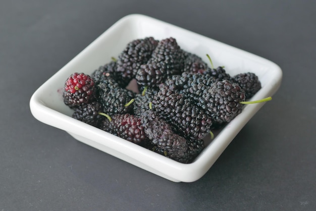 Fresh blackberry in a white bowl on table