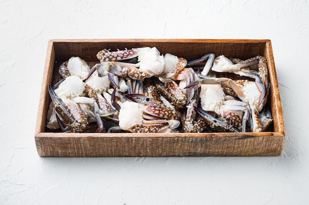 Fresh blue swimming crab parts set, in wooden box, on white background