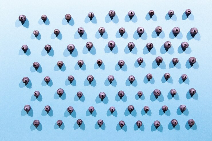 Photo fresh blueberries arranged in line in blue background