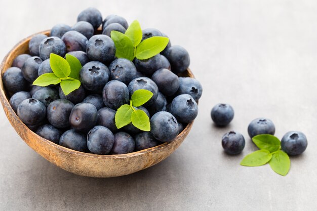 Fresh blueberries in a bowl on gray.