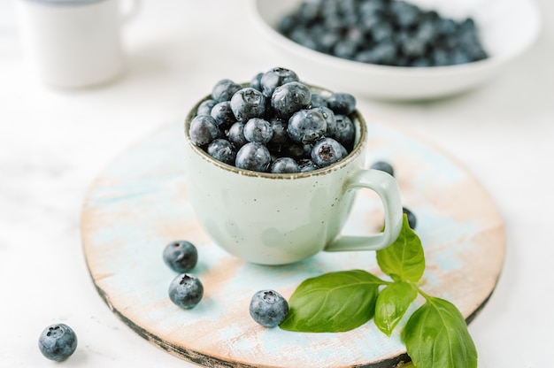 Fresh blueberries in a cup on white background