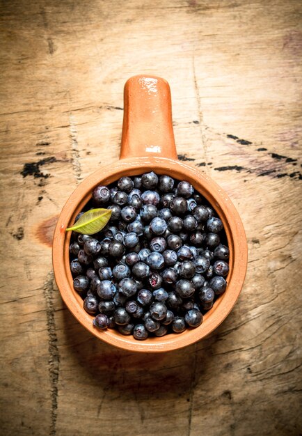 Fresh blueberries in a Cup. On a wooden table.