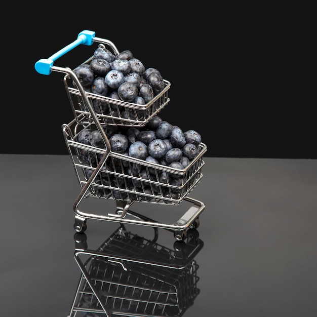 Fresh blueberries in a grocery basket on a background with a mirror image. vitamin food for health