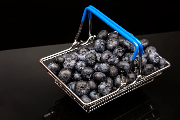 Fresh blueberries in a grocery basket on a background with a
mirror image. vitamin food for health