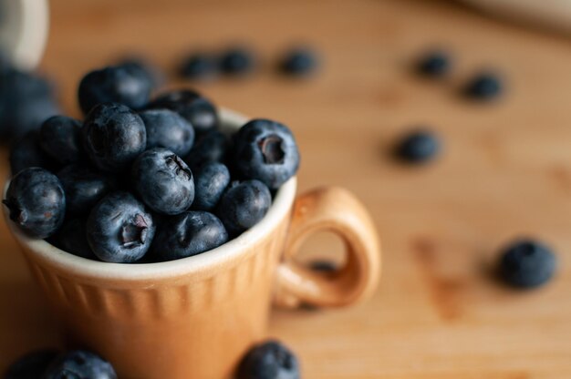 Fresh blueberries in terracotta cup Close up Top view Selective focus