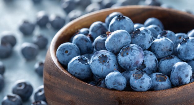 Fresh blueberries in wooden bowl close up