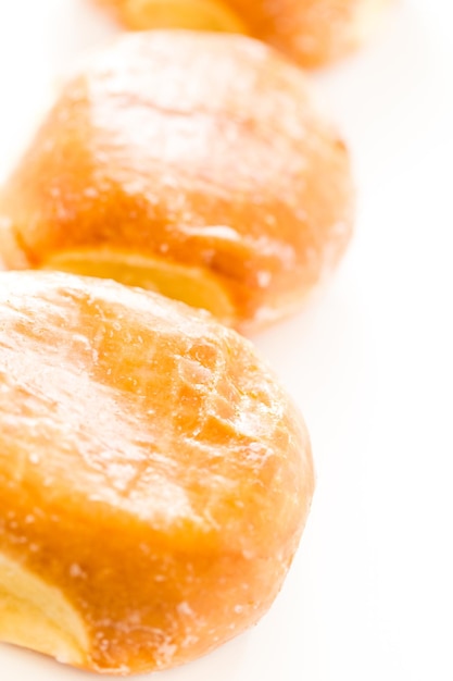 Fresh blueberry jelly filled donuts on a white background.