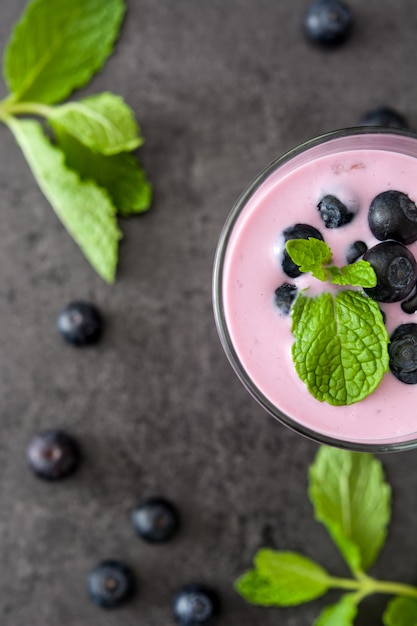 Fresh blueberry smoothie on black stone top view