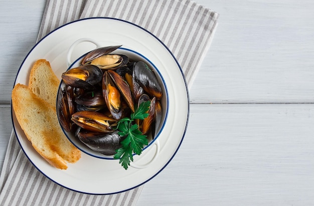 Fresh Boiled mussels Black Sea with white bread on a white wooden table no people