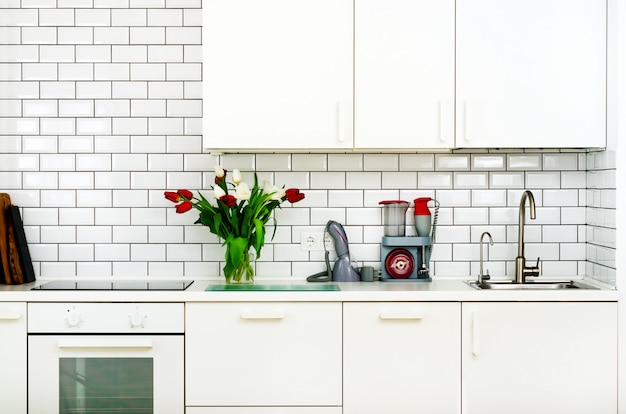 Fresh bouquet of red and white tulips on kitchen table. Detail of home interior, design. 