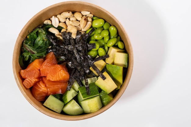 Photo fresh bowl with salmon green beans rice nuts and seaweed on the white background