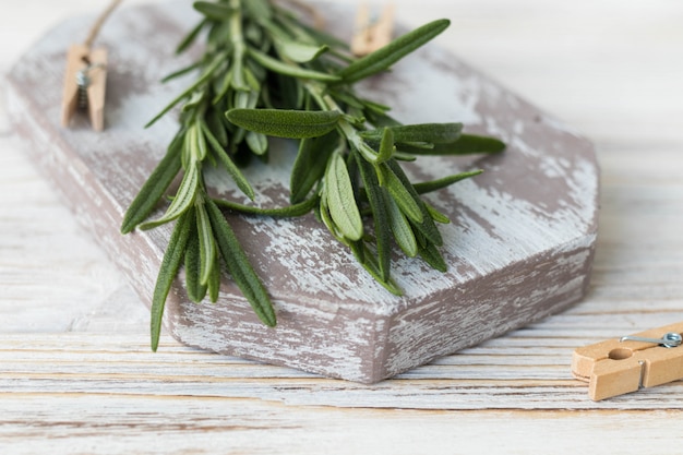 Fresh branches of rosemary on a white wooden table