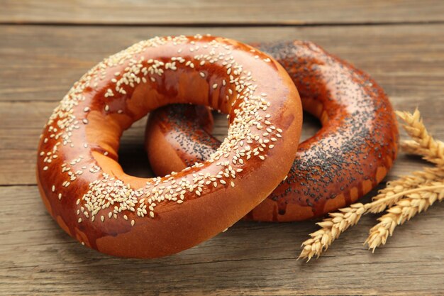 Photo fresh bread bagel with poppy seed on grey wooden background