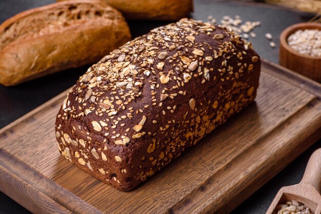 Fresh Bread on black background, top view, copy space. Homemade fresh baked various loafs of wheat and rye bread