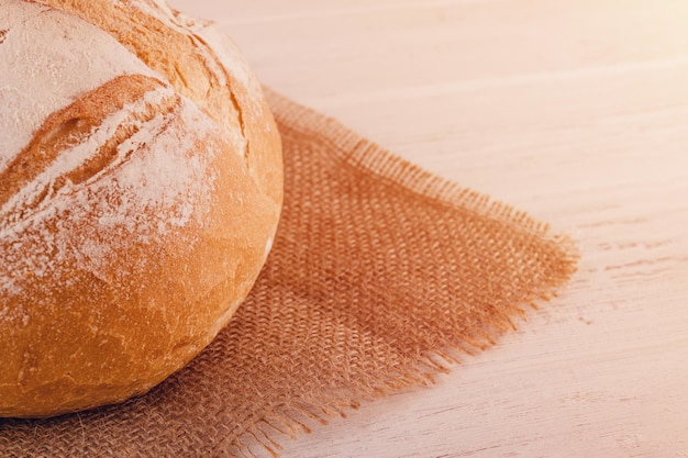 Fresh bread on burlap on a wooden table