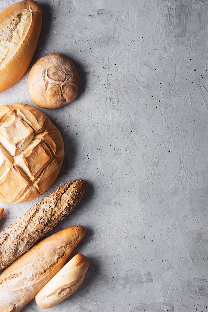 Fresh bread on a gray concrete background. Top view with copy space