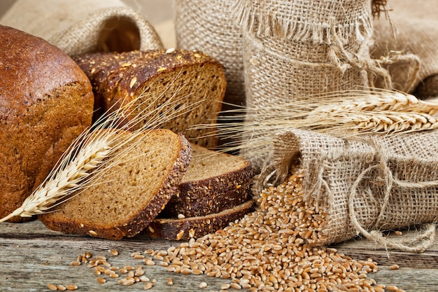 Pane fresco su uno sfondo vecchio con accessori da cucina sul tavolo