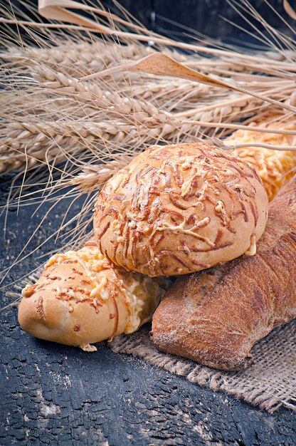 Fresh bread on old wooden table decorated with ears