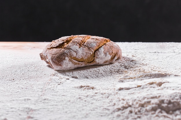 Fresh bread on table closeup in flour placer