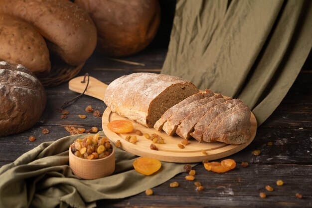 Foto pane fresco e grano su uno sfondo di legno rustico pane di segale appena cotto a fette