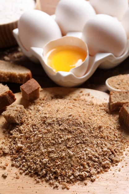 Fresh breadcrumbs and eggs on wooden table