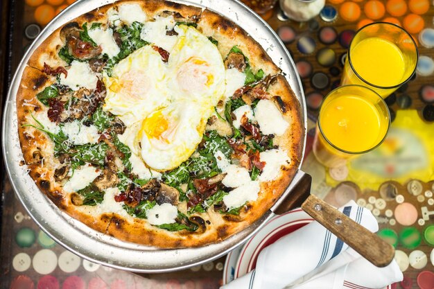 Fresh breakfast pizza with three farm fresh eggs in Italian restaurant.