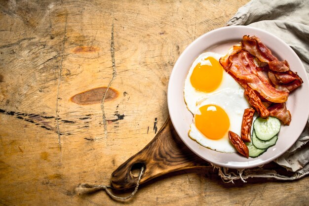 Photo fresh breakfast plate fried eggs with bacon and tomatoes on a wooden table