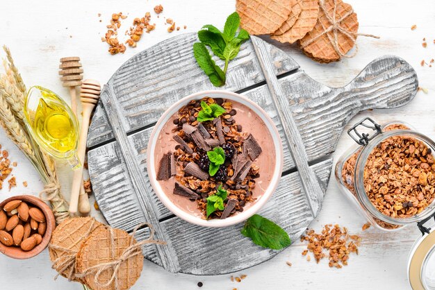 Свежий завтрак с йогуртом, мюсли, шоколадом и ягодами в миске Вид сверху Свободное место для текста