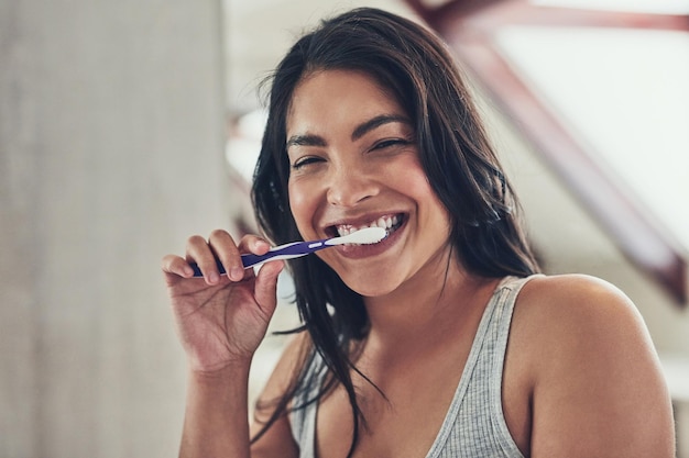 Alito fresco per iniziare un nuovo giorno ritratto di una giovane donna attraente lavarsi i denti a casa