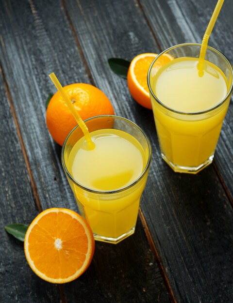 Fresh bright homemade orange juice on wooden table close up