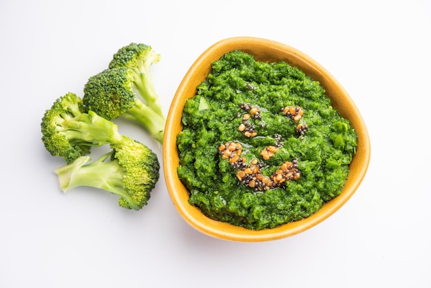 Fresh broccoli chutney or paste puree in the bowl with raw pieces