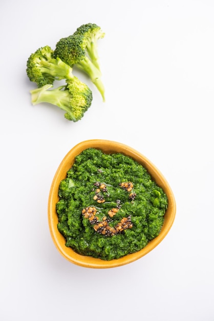 Fresh broccoli chutney or paste puree in the bowl with raw pieces