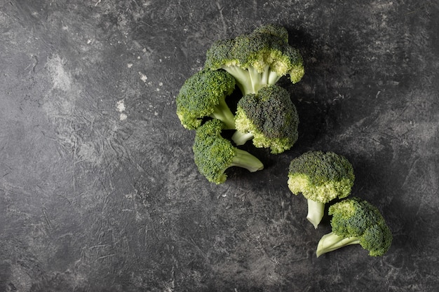 Fresh broccoli on a dark table, top view concept