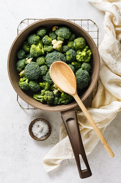 Photo fresh broccoli in a pan on a light background
