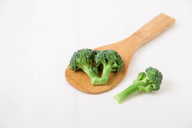 Fresh broccoli in the spoon, white.