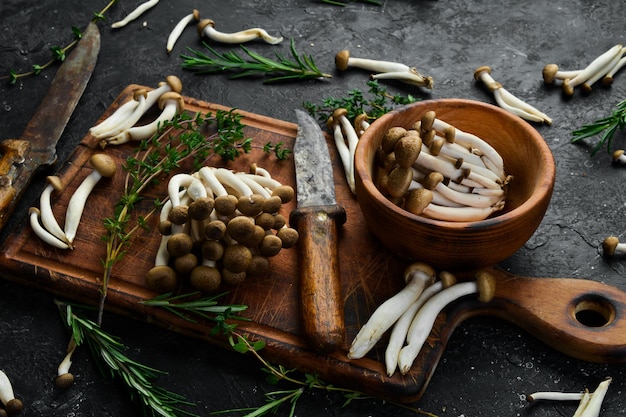 Fresh brown beech mushroom on black background on a stone table Side view