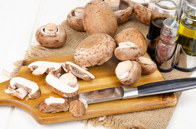 Fresh brown cultivated mushrooms champignons on wooden background. Studio Photo.