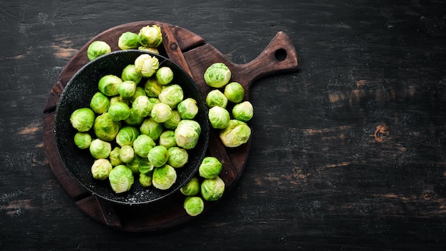 Fresh Brussels cabbage on a black background Vegetables Top view Free space for your text