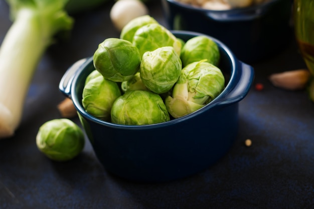 Fresh Brussels sprouts in bowl on a dark background